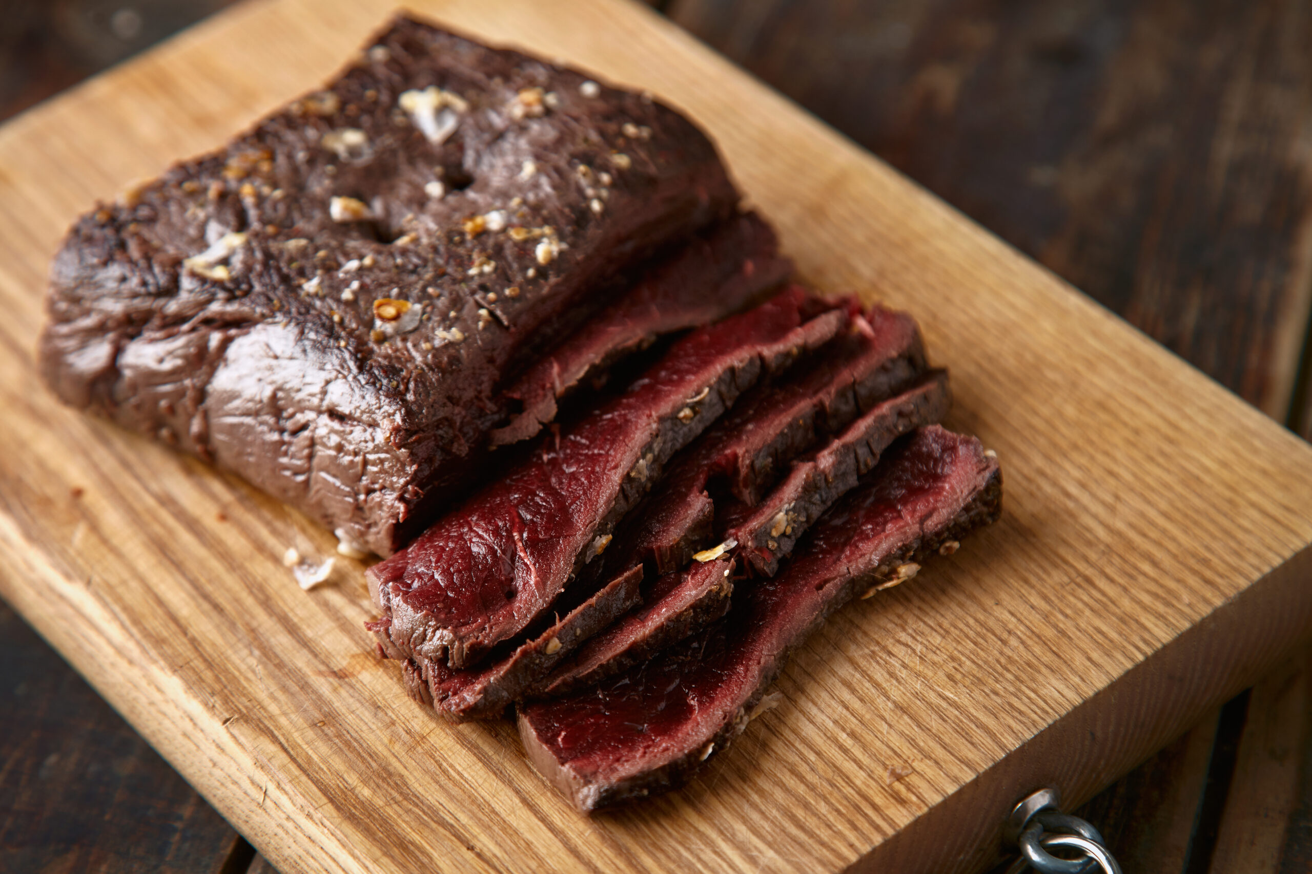 Tender corned beef brisket sliced with a side of potatoes and cabbage.